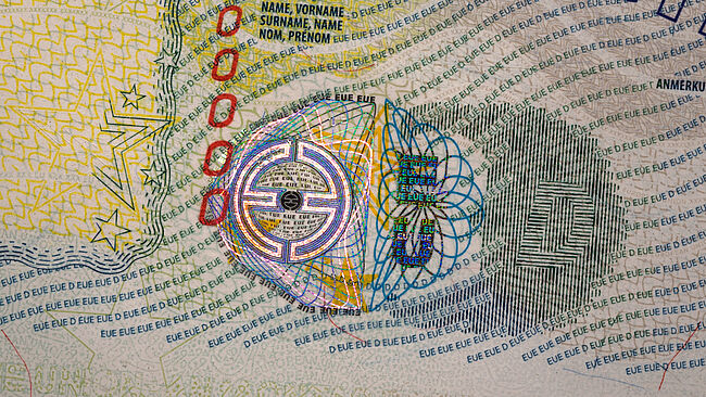 Primer plano de la función de seguridad de punto CERO de KINEGRAM en la visa de la UE que muestra un logotipo de la UE y un diseño Guilloche de línea fina
