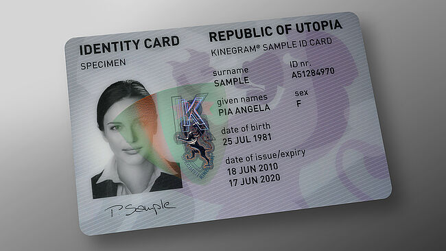 Image of polycarbonate ID card with embedded KINEGRAM showing a red-green flip effect
