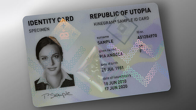 Image of polycarbonate ID card with embedded KINEGRAM security feature showing a diamond-shaped design