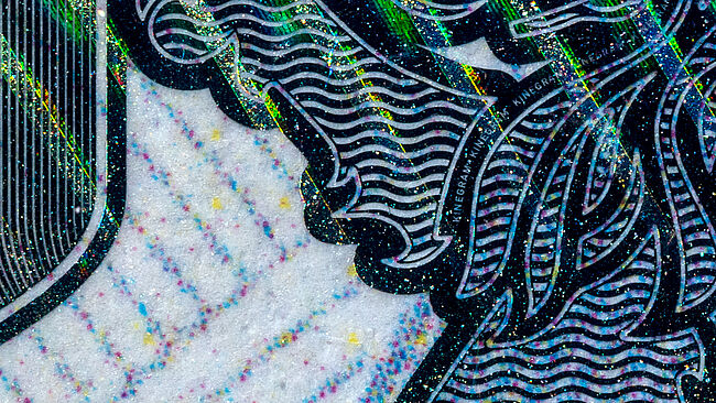Microscopic close-up of a KINEGRAM HDM: Using line widths down to 10-15 microns, KINEGRAM elements with sophisticated design patterns can be realized