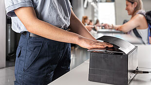 Image of Border Control Officer machine-scanning a passport to authenticate the KINEGRAM security feature