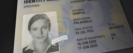Close-up image of a sample passport's data page, focusing on the portrait, which is secured against manipulation with a KINEGRAM Primary Image Protection feature.