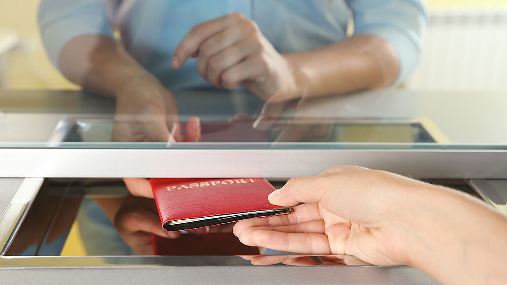 Image showing how a passport is handed over to a municipality employee for inspection.