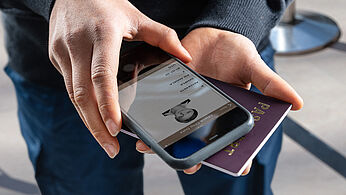 Imagen de las manos del oficial de policía autenticando la función KINEGRAM en una tarjeta de identificación con su smartphone